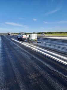 Aplicación de producto desengrasante en pista aeroportuaria durante la limpieza de caucho