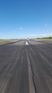 Aplicación de producto desengrasante en pista aeroportuaria durante la limpieza de caucho